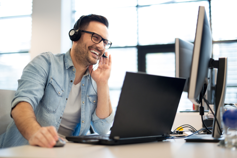 Young smiling male call center operator doing his job